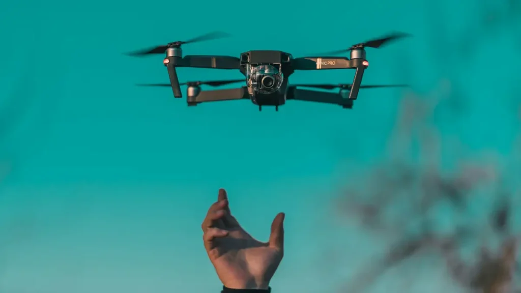 A mini drone hovering near an outstretched hand